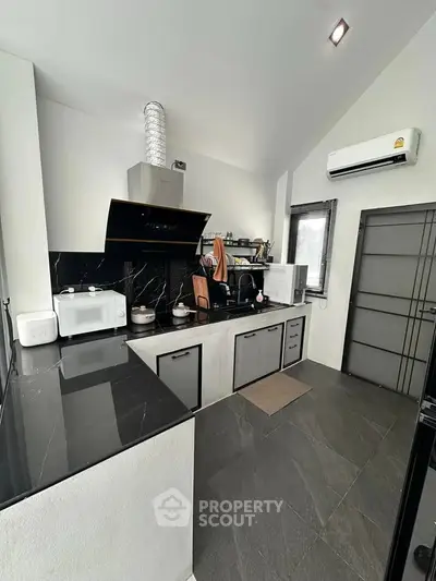 Modern kitchen with sleek black countertops and appliances