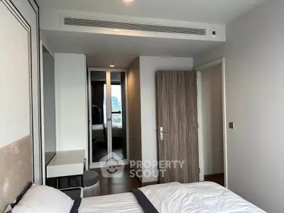 Modern bedroom with sleek design and city view, featuring stylish furniture and ample natural light.