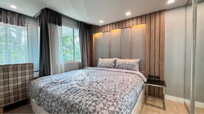 Modern bedroom with stylish decor and large windows offering natural light.