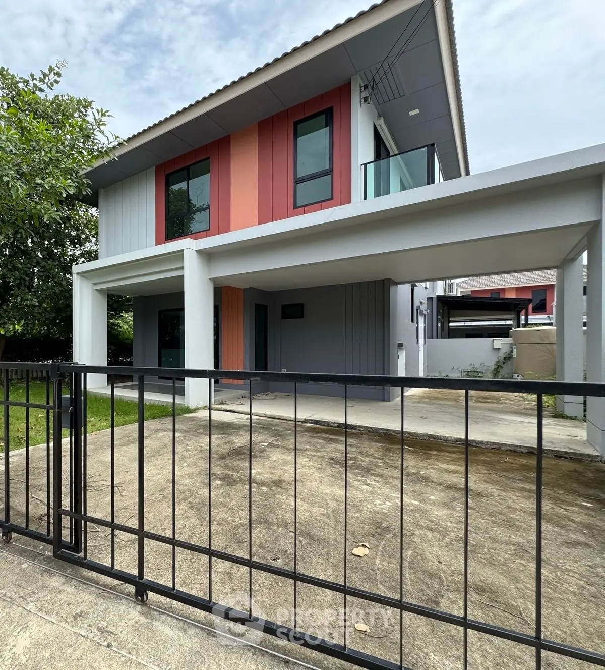 Modern two-story house with unique facade and spacious driveway in a suburban setting.