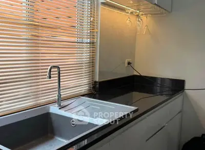 Modern kitchen with sleek countertops and stylish blinds, perfect for culinary enthusiasts.