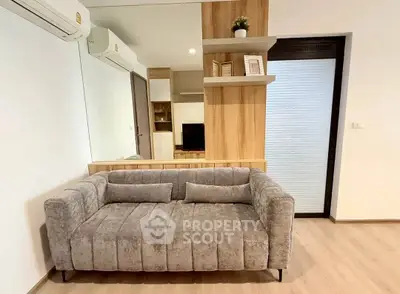 Modern living room with stylish gray sofa and wooden accents, perfect for cozy relaxation.