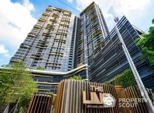 Modern high-rise condominium with sleek design and lush greenery at The Line Jatujak-Mochit.