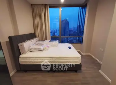 Modern bedroom with city view and large windows in high-rise apartment