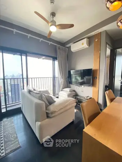 Modern living room with city view, featuring cozy seating and sleek decor.