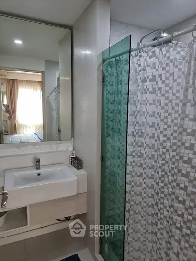 Modern bathroom with glass shower and stylish sink in a bright apartment.