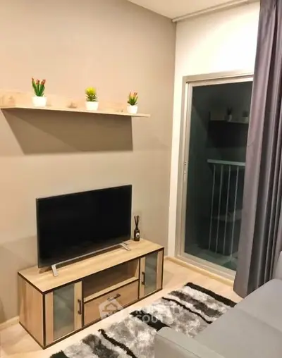 Modern living room with TV, stylish decor, and balcony access.