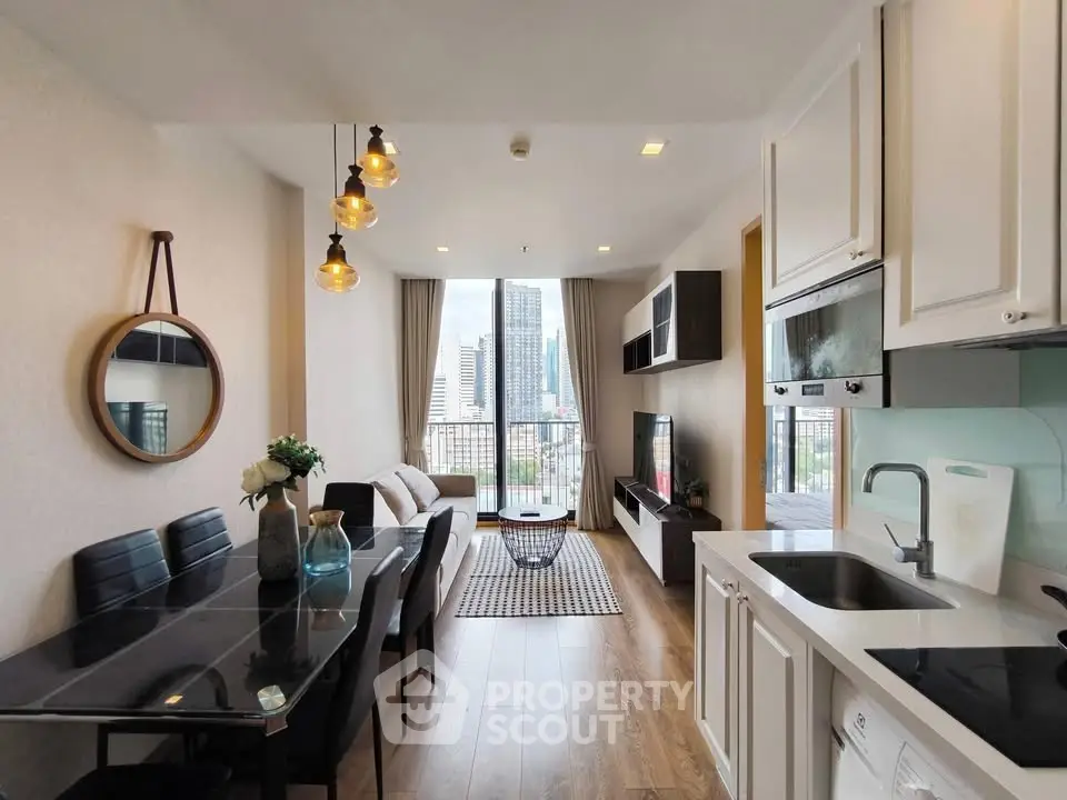 Modern open-plan living room with city view, stylish decor, and elegant kitchen area.