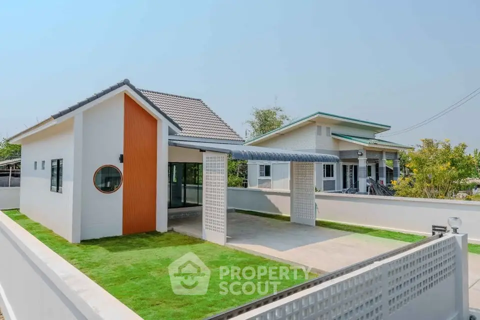 Modern single-story home with spacious driveway and manicured lawn, showcasing contemporary architecture.