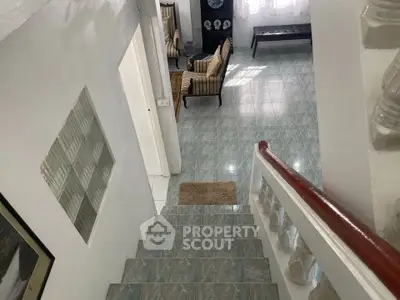 Charming interior view of a cozy home with tiled floors and elegant staircase, perfect for comfortable living.