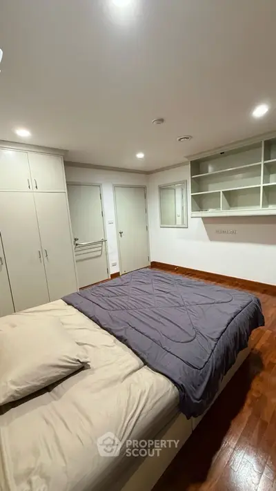 Spacious bedroom with wooden flooring and built-in wardrobe