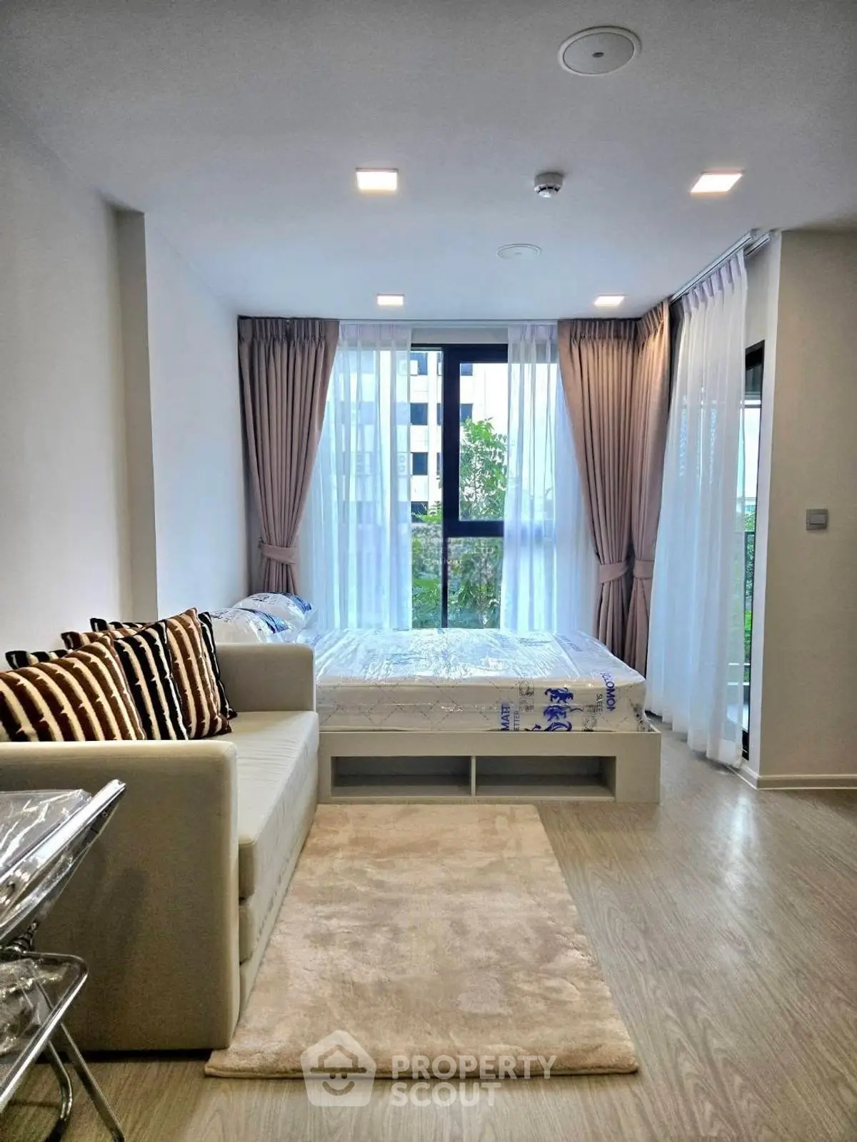 Modern bedroom with large window and stylish decor in a cozy apartment