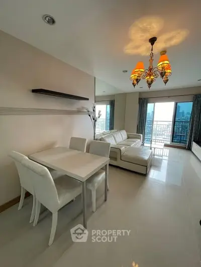 Elegant living room with modern chandelier and city view balcony.