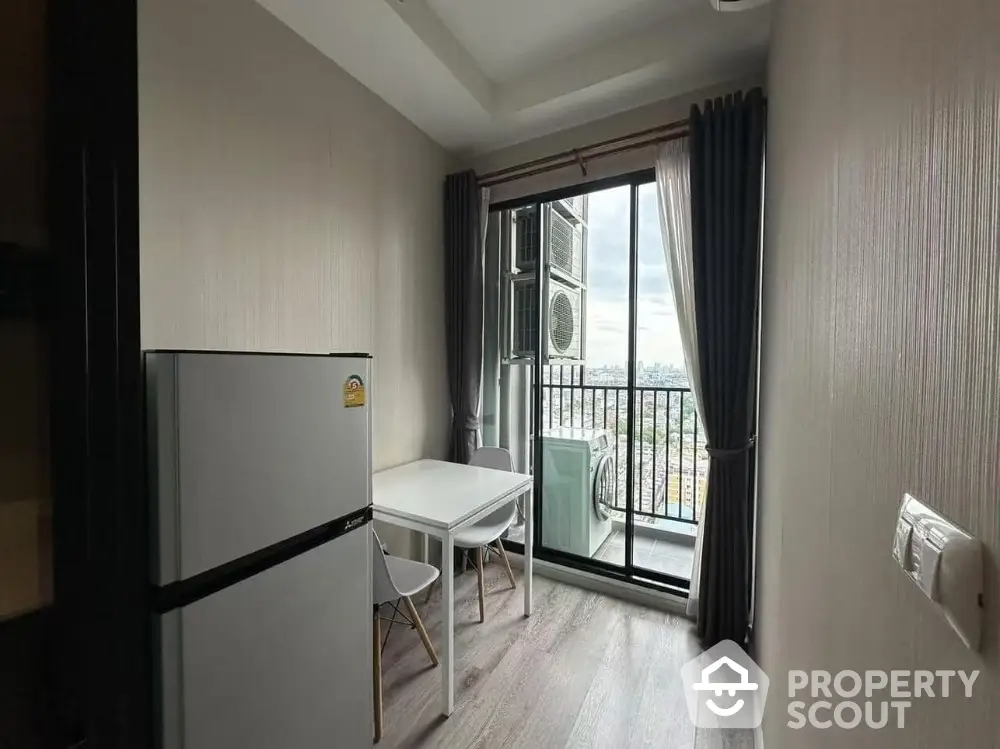 Compact kitchen dining area with balcony view and modern appliances