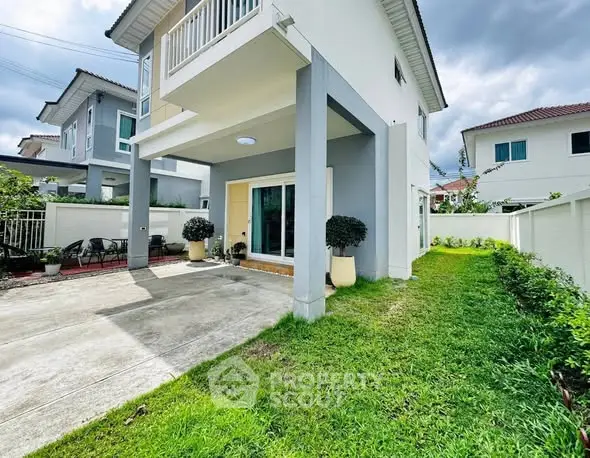 Modern two-story house with spacious driveway and lush green lawn, perfect for family living.