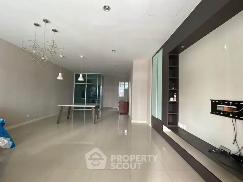 Spacious modern living room with sleek design and elegant lighting fixtures.