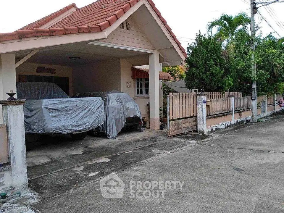 Charming suburban home with covered driveway and lush greenery, perfect for family living.