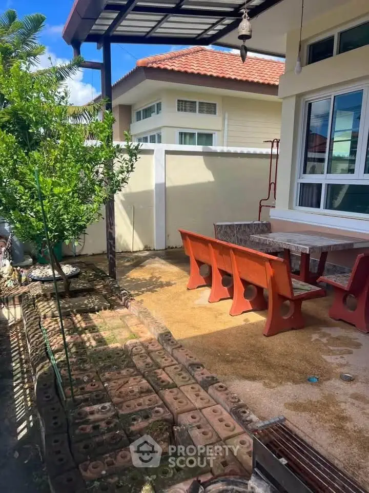 Charming outdoor patio with seating area and lush greenery, perfect for relaxation and entertaining.