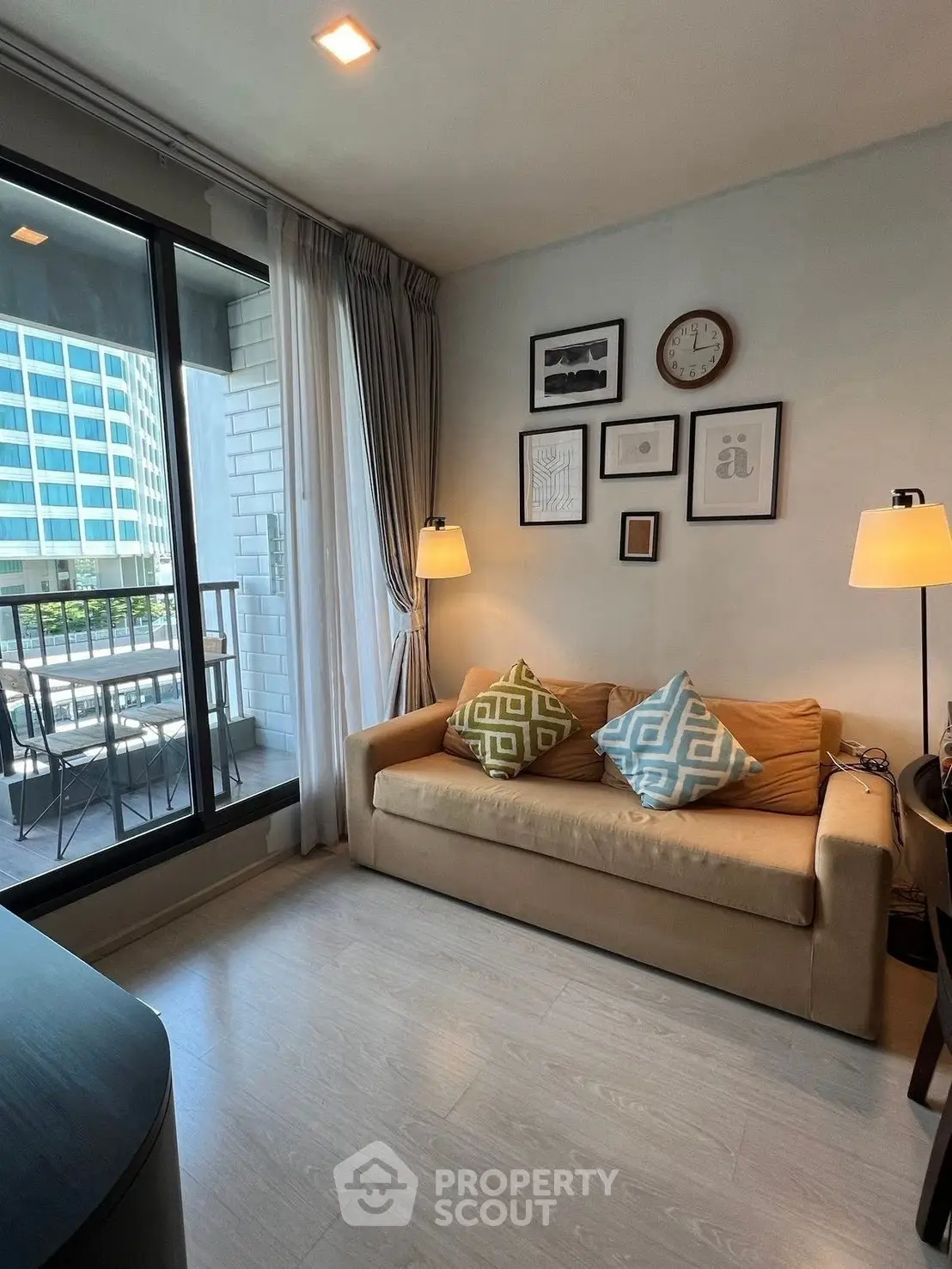 Cozy living room with modern decor and balcony view in urban apartment.