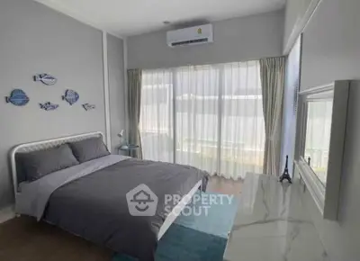 Modern bedroom with stylish decor and large window for natural light.