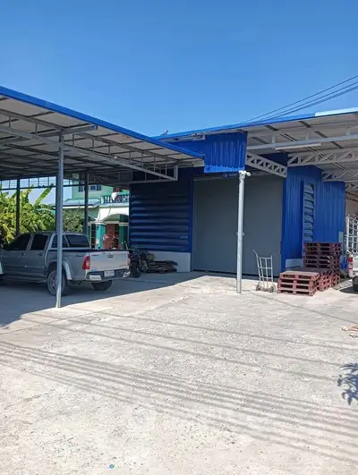 Spacious industrial warehouse with ample parking and modern blue exterior.