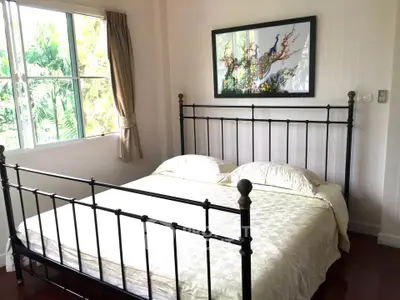 Cozy bedroom with elegant metal bed frame and large window view