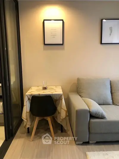 Cozy living room with modern sofa and small dining area, perfect for urban living.