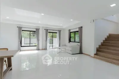 Spacious modern living room with large windows and natural light