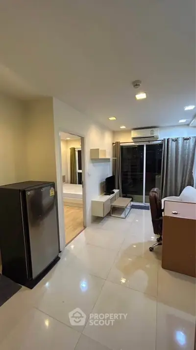 Modern living room with sleek design and open layout, featuring a cozy workspace and stylish decor.