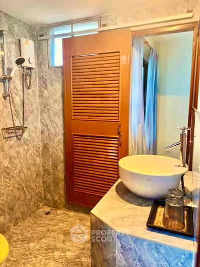 Modern bathroom with marble tiles and stylish basin in a cozy home.