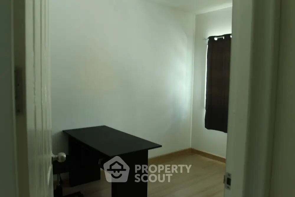 Minimalist study room with desk and window, ideal for focused work.