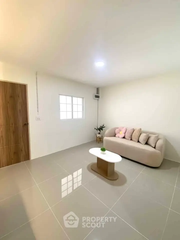 Minimalist living room with modern sofa and sleek coffee table in bright, airy space.