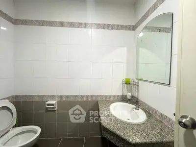 Modern bathroom with sleek design and granite countertop in a contemporary home.