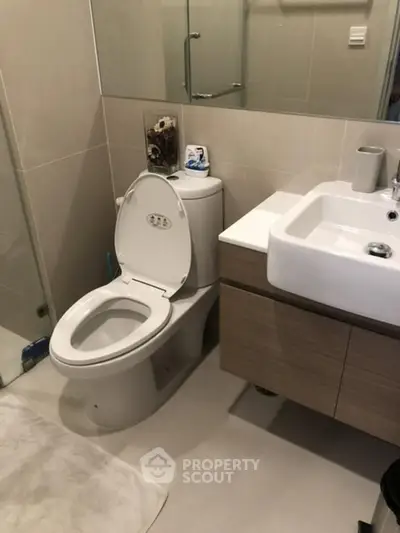Modern bathroom with sleek fixtures and neutral tones, featuring a stylish vanity and spacious shower area.