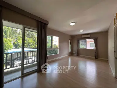 Spacious empty living room with large windows and balcony access