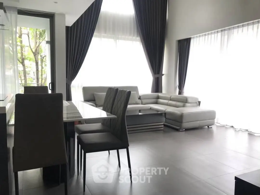 Spacious modern living room with large windows and elegant furniture