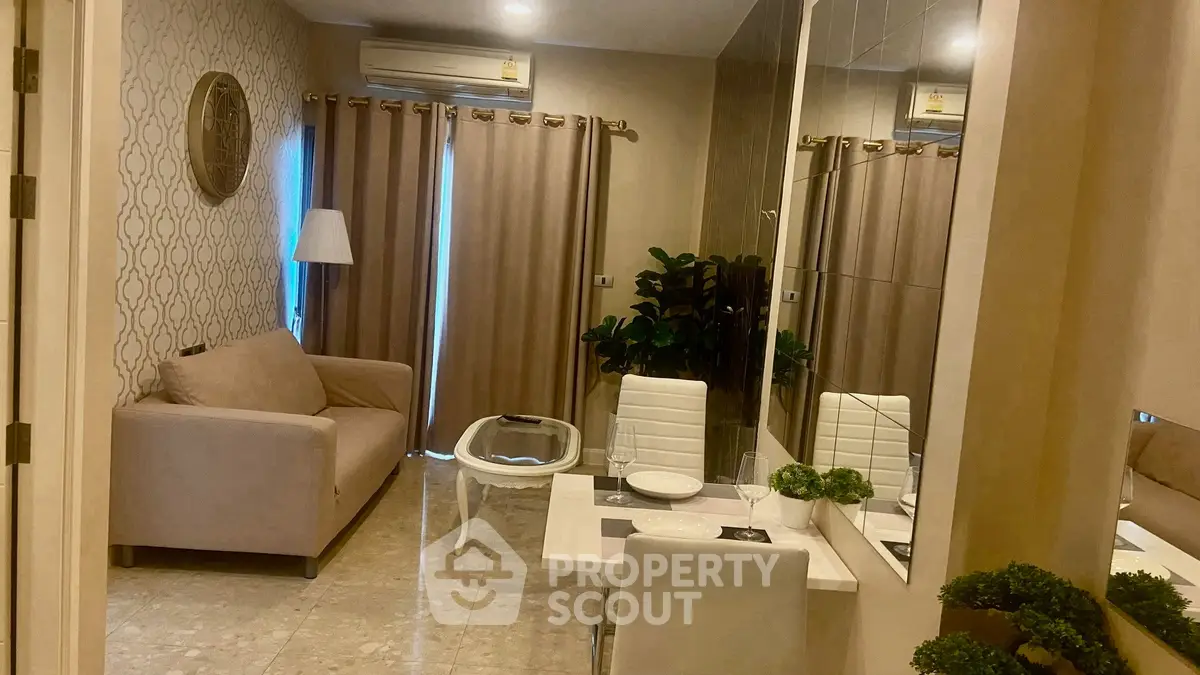 Cozy living room with modern decor and dining area, featuring a comfortable sofa and elegant table setting.