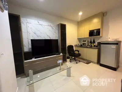 Modern living room with sleek TV setup and compact kitchen area