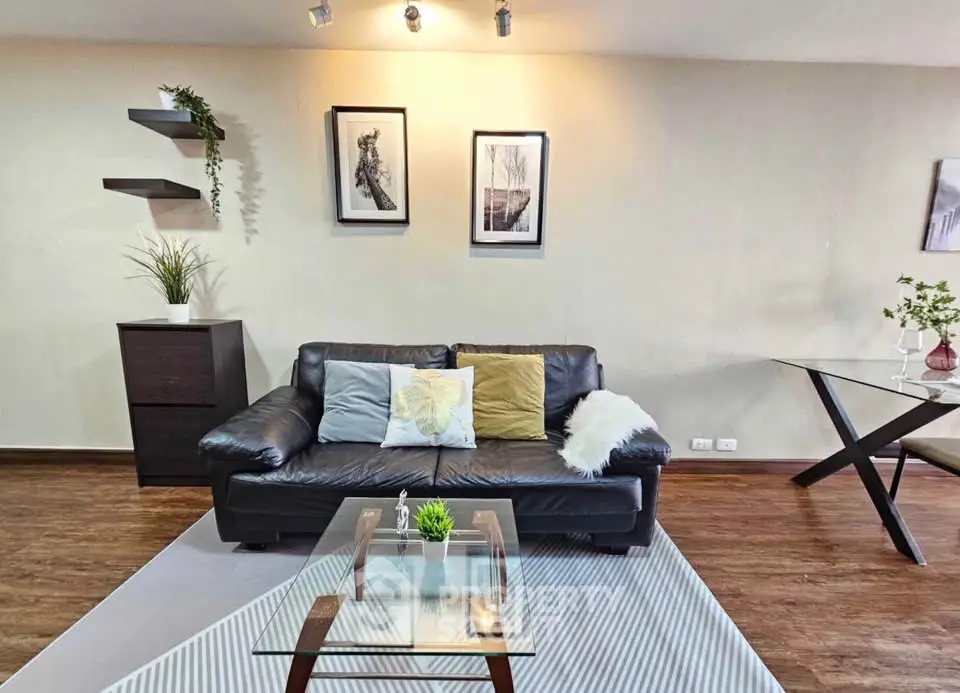 Stylish living room with modern decor, leather sofa, and glass coffee table in a cozy apartment.
