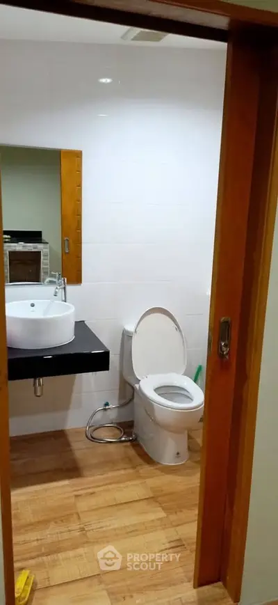 Modern bathroom with wooden flooring and sleek fixtures