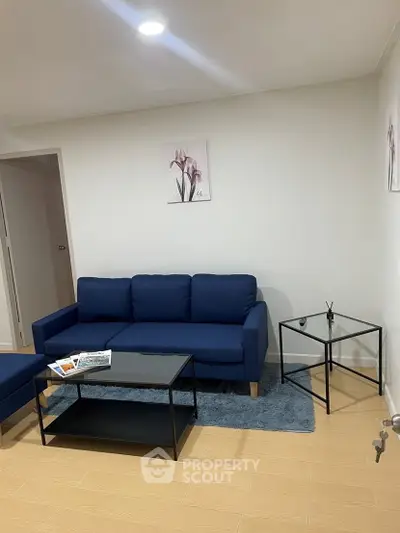 Modern living room with blue sofa and minimalist decor in a cozy apartment.