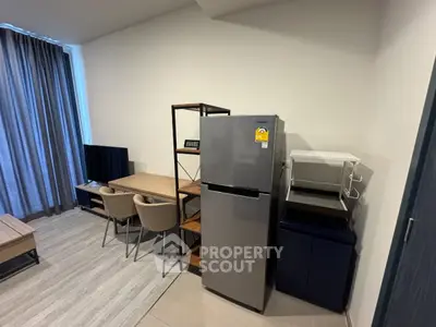 Modern living room with dining area and sleek appliances in a stylish apartment.