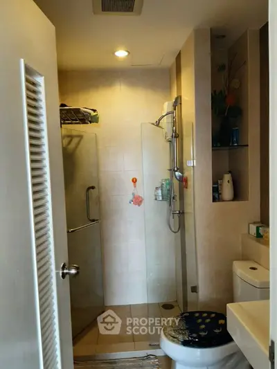 Modern bathroom with glass shower and sleek fixtures in cozy apartment.