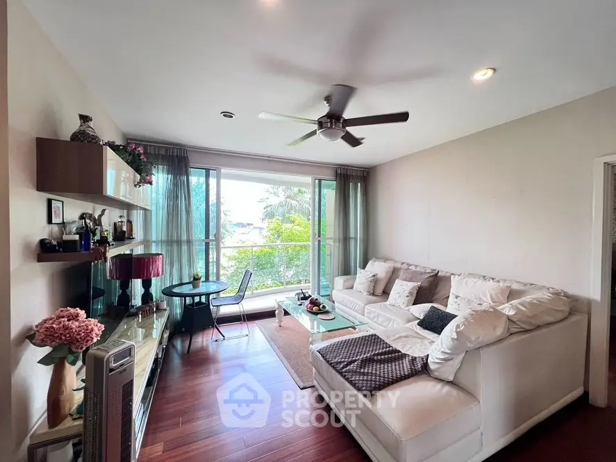 Spacious living room with modern decor and large windows overlooking greenery.