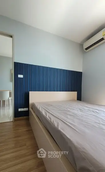 Modern bedroom with stylish blue accent wall and wooden flooring