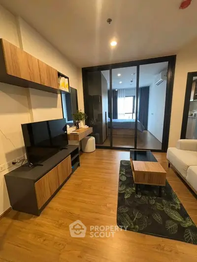 Modern living room with wooden flooring and stylish furniture in a cozy apartment setting.