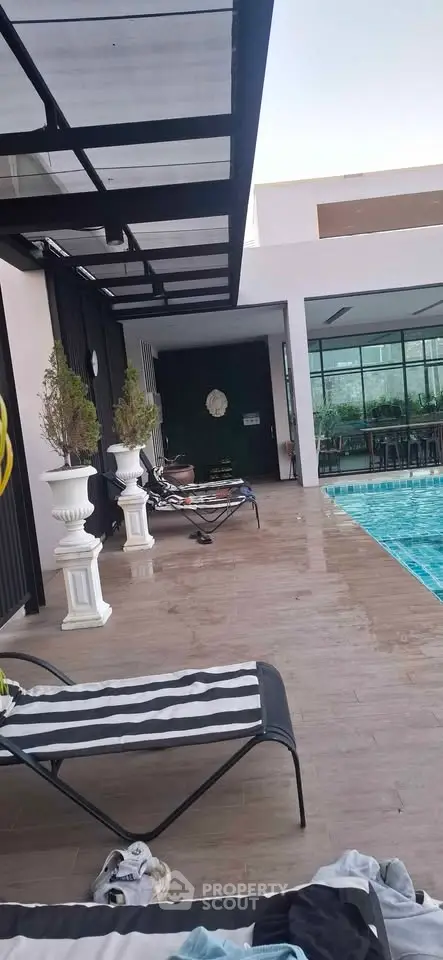 Luxurious poolside area with stylish loungers and modern architecture, perfect for relaxation and leisure.