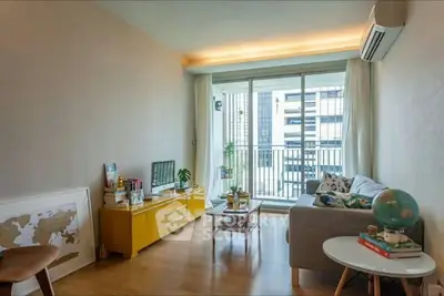 Bright and cozy living room with modern decor and balcony view in urban apartment.