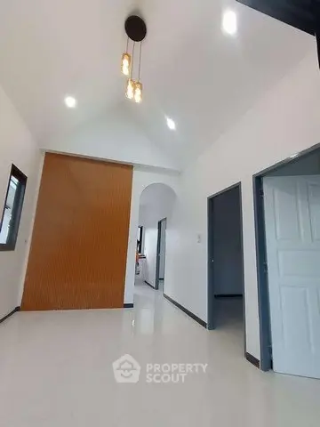 Modern interior hallway with high ceiling and elegant lighting in a contemporary home.