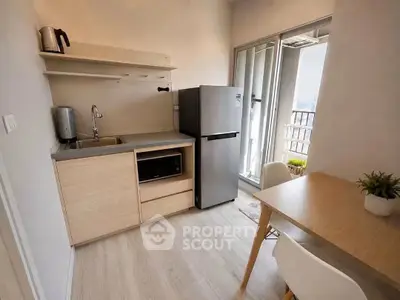 Modern compact kitchen with dining area and balcony view in urban apartment